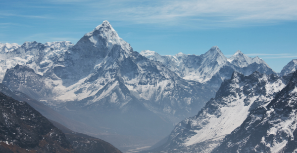 Traveler with durable luggage in the snowy Himalayas during winter expedition